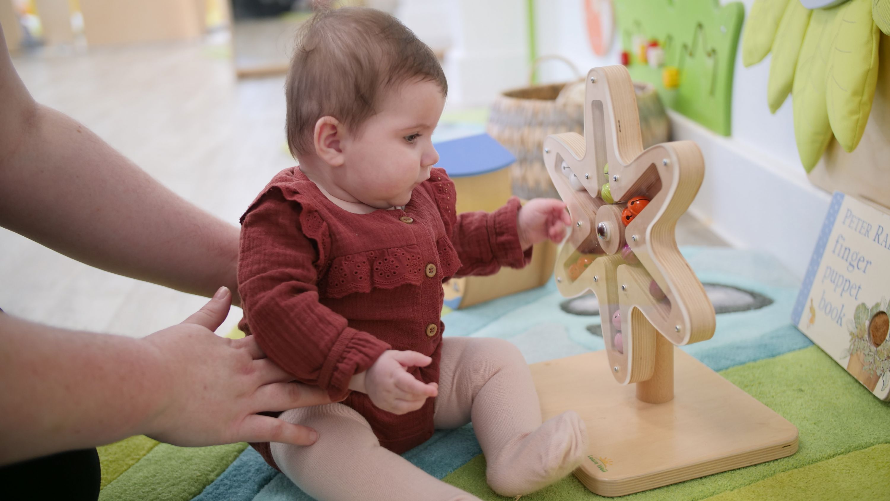 Baby playing with a toy at Lingfield Nursery