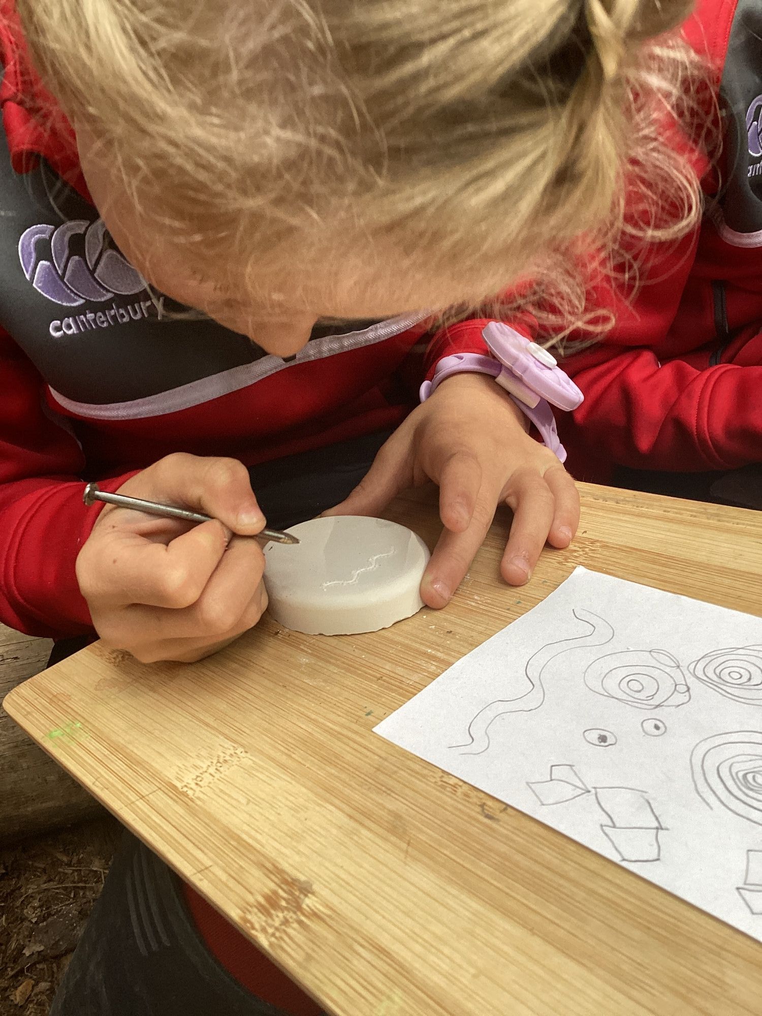 Lingfield Prep student carving a picture at Wilderness Wood